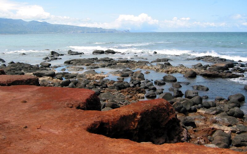 rocky coastline with red sand