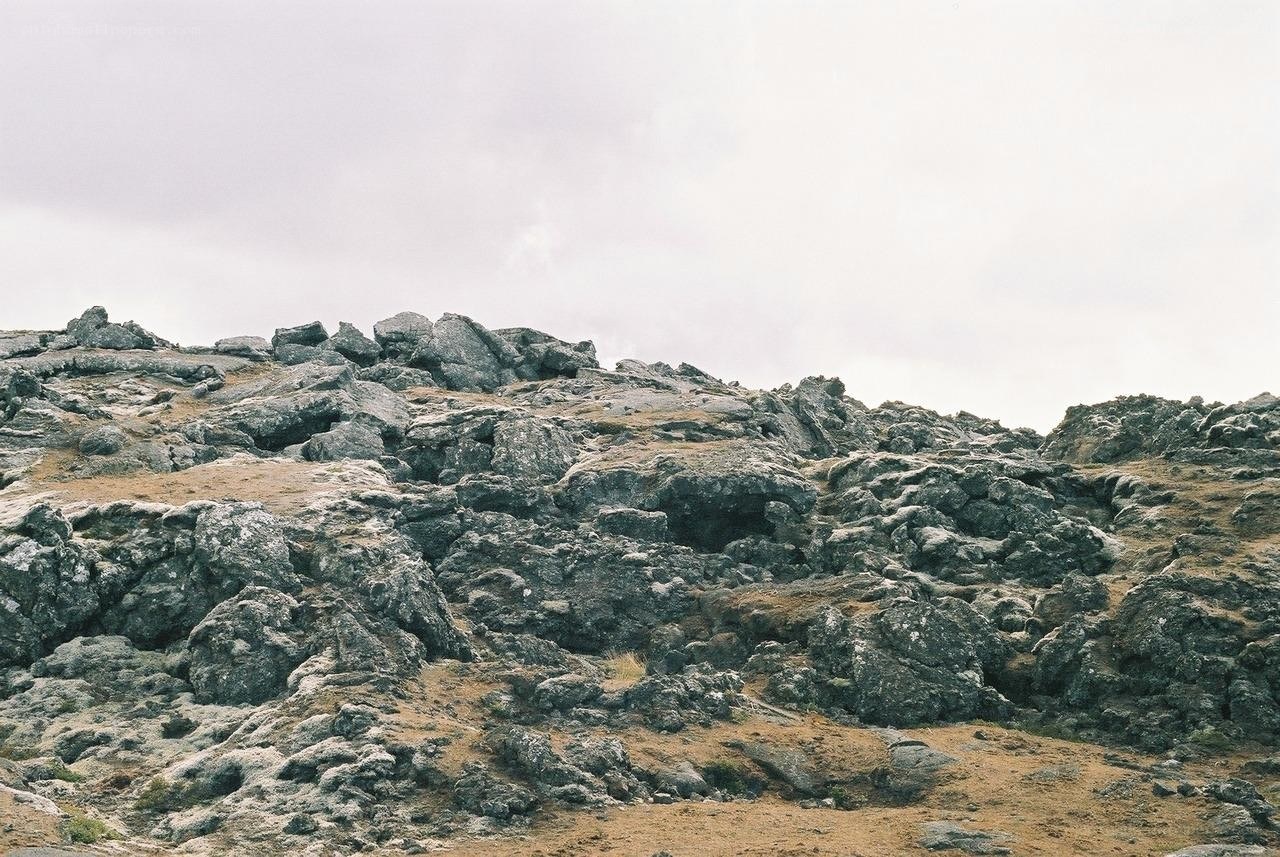 rocky hill under cloudy sky
