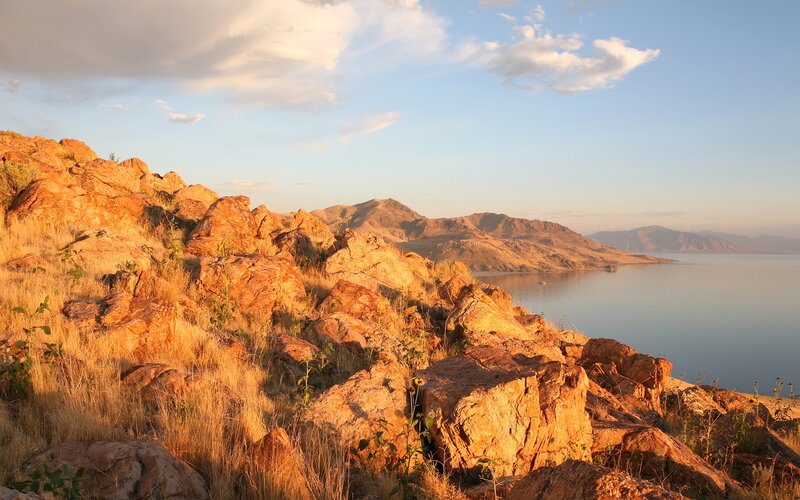 Rocky Hillside by Lake — Orange, Serene, Sunset