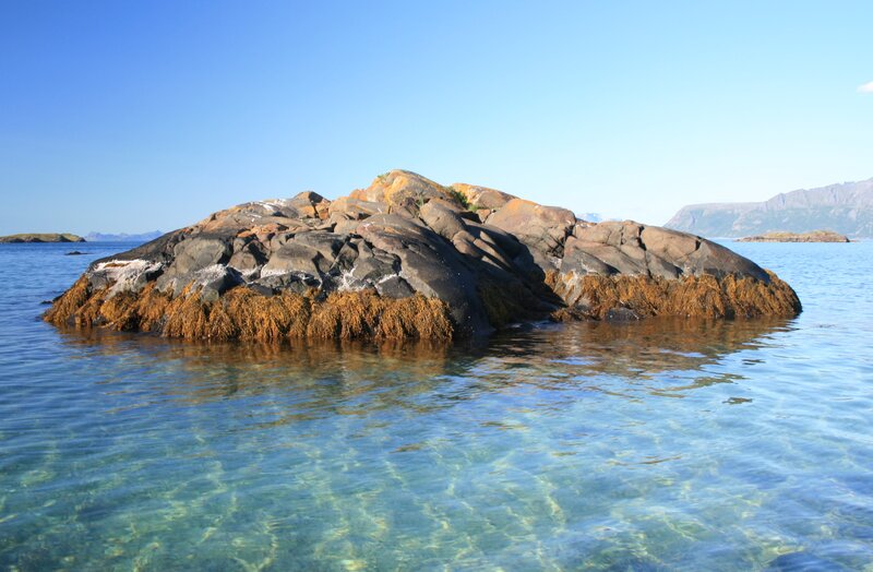 Rocky islet in clear blue water