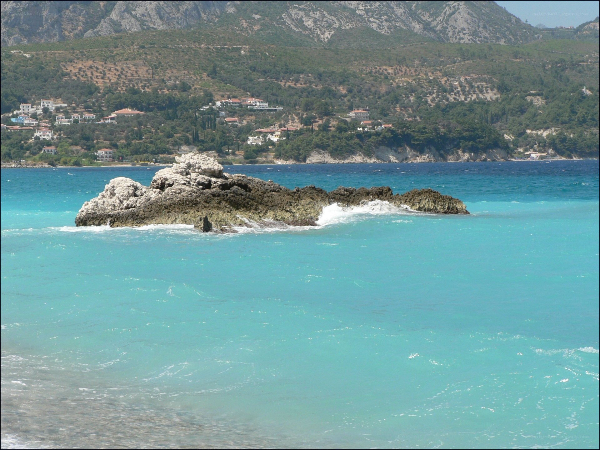 Rocky islet in turquoise sea