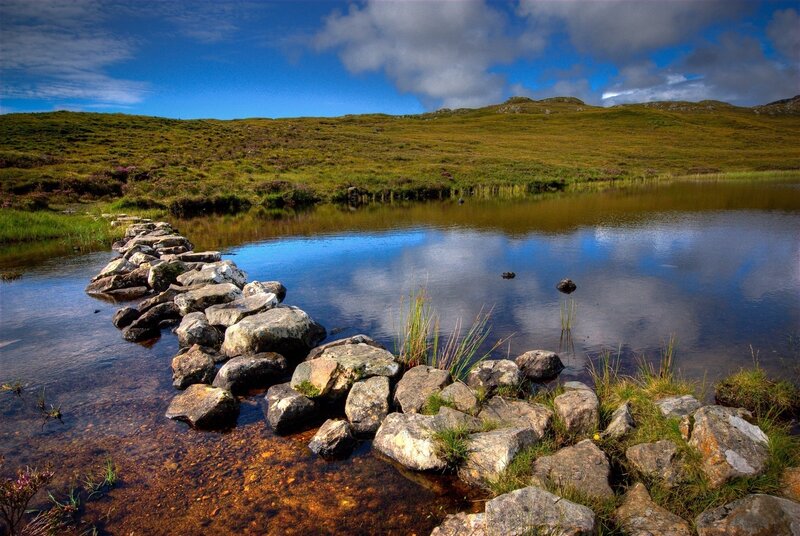 Rocky path across a serene loch