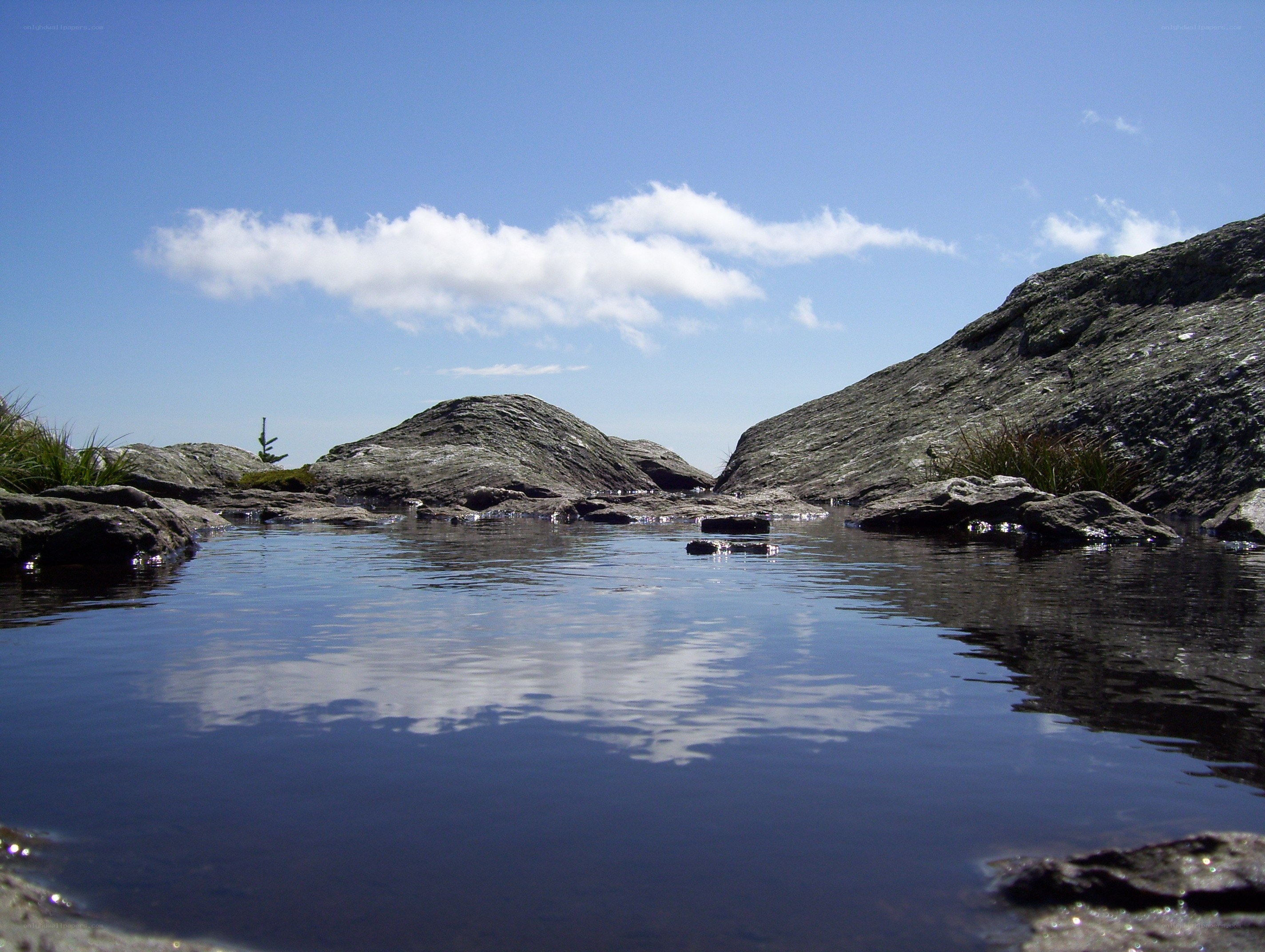 Rocky pond under blue sky
