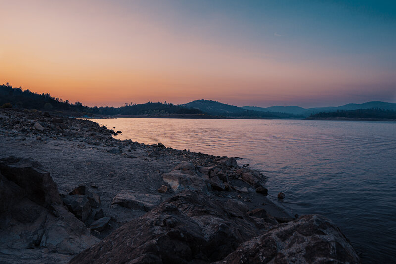 Rocky Shore at Sunset — Orange, Serene, Photograph, Lake, Mountains