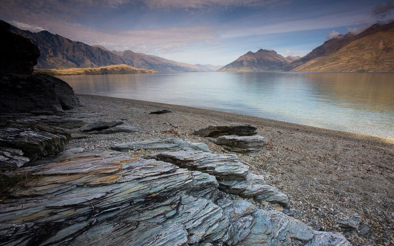 Rocky Shore by Lake — Blue, Serene, Afternoon, Photograph, Mountains