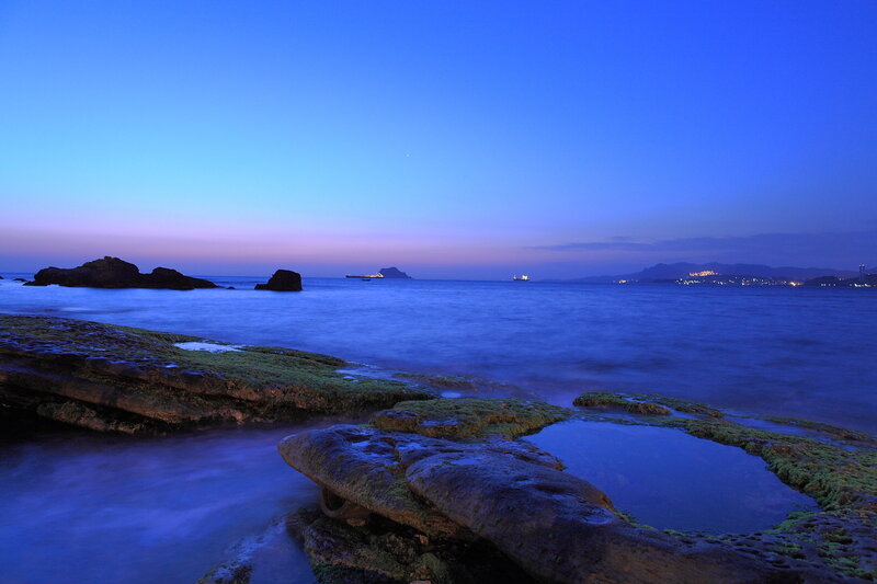 Rocky Shoreline at Dusk — Blue, Serene, Night, Photograph, Rocks
