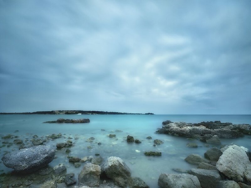 Rocky Shoreline at Sea — Blue, Calm, Photograph, Rocks