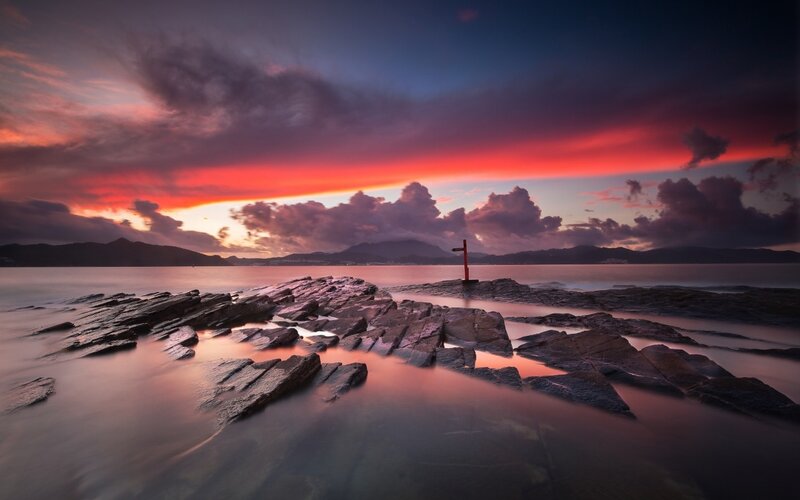 Rocky Shoreline at Sunset — Red, Dramatic, Photograph, Sky, Mountains