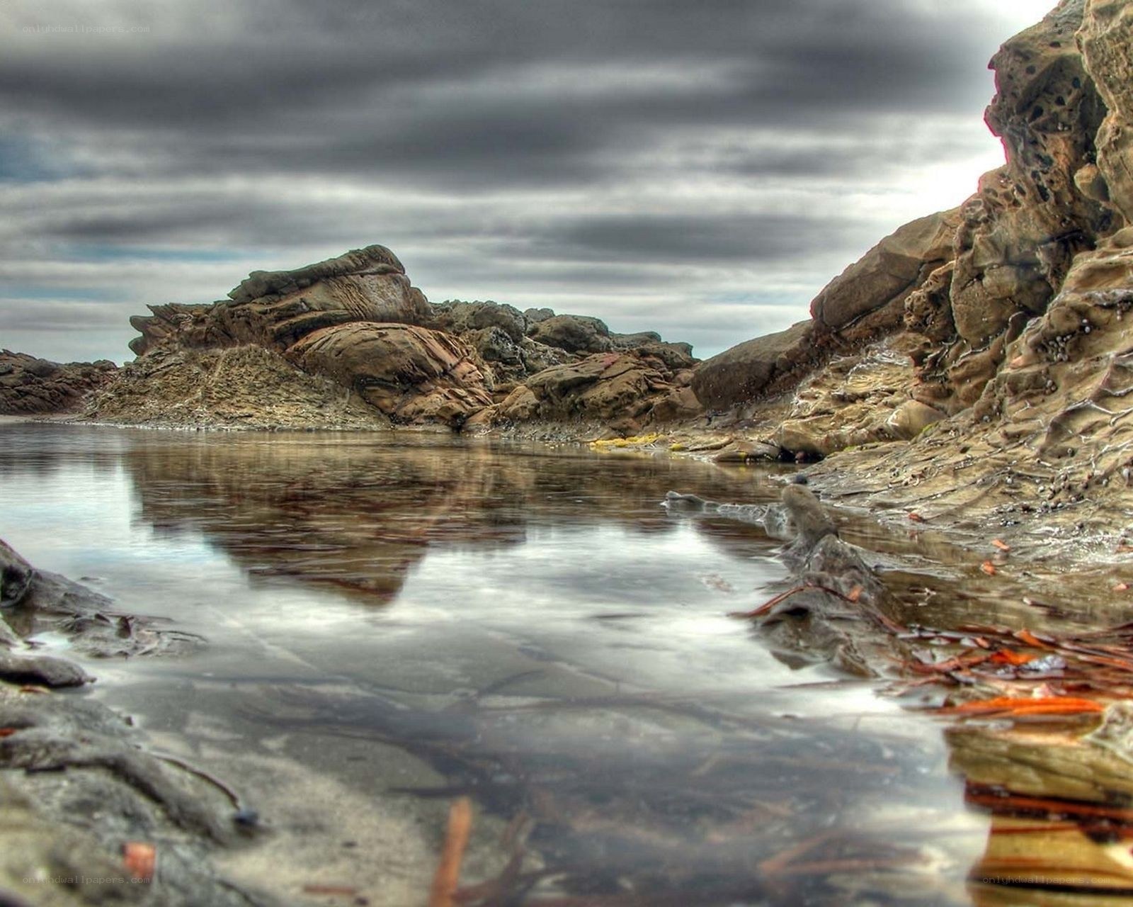 Rocky shoreline under cloudy sky