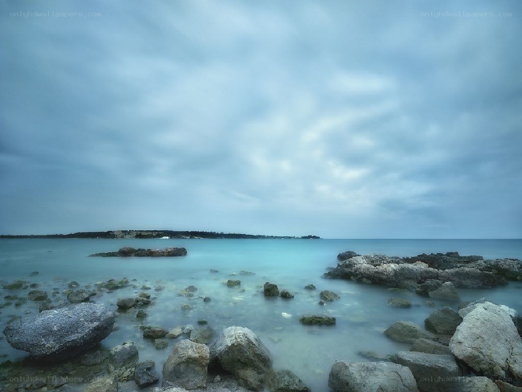 Rocky shoreline under cloudy sky