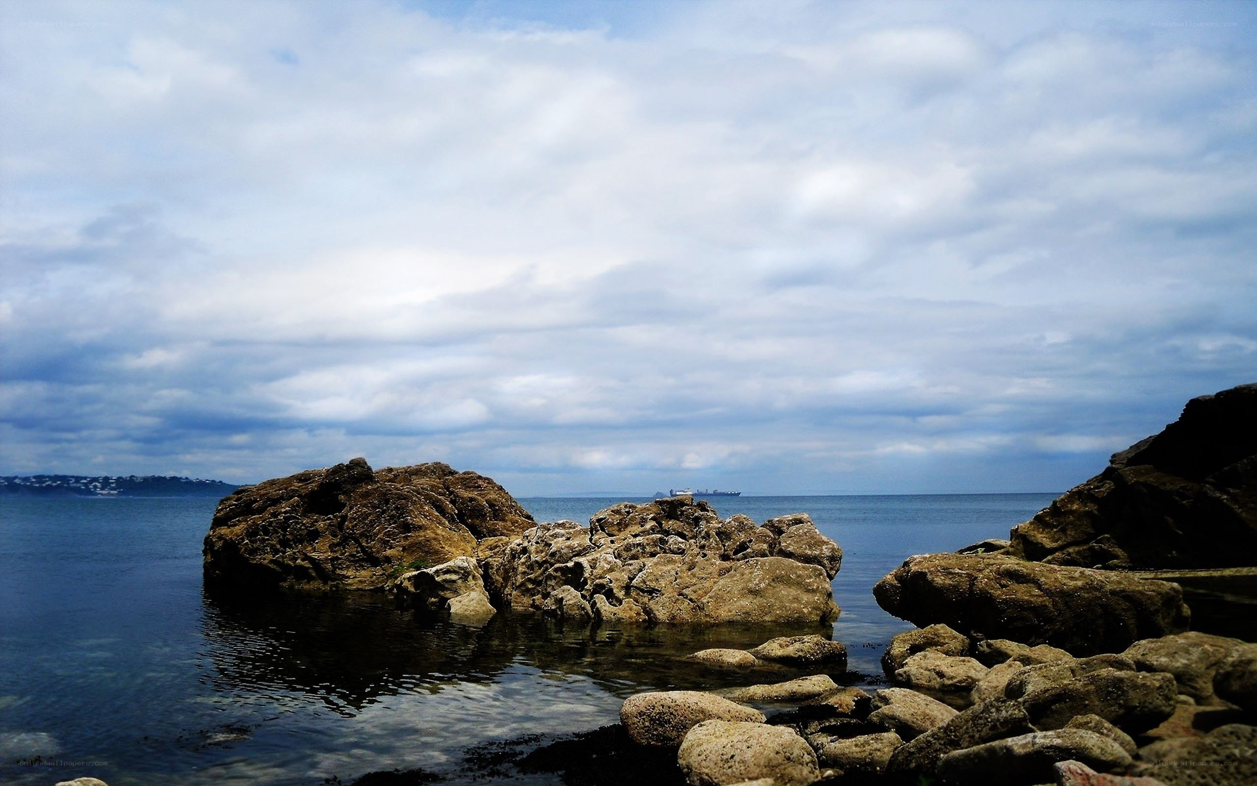 Rocky shoreline under cloudy sky