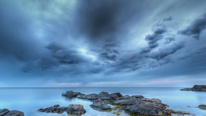Rocky Shoreline under Storm Clouds