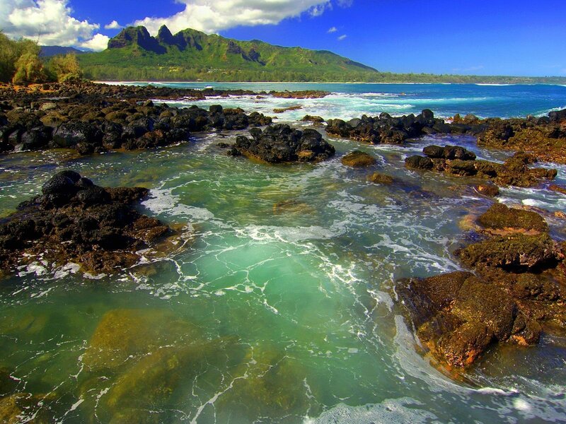 Rocky shoreline with green mountains