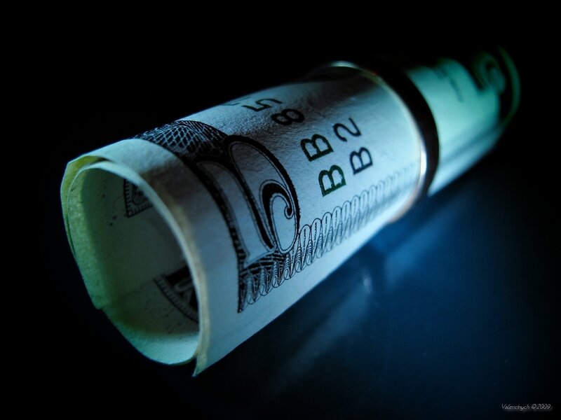 rolled dollar bill under blue light