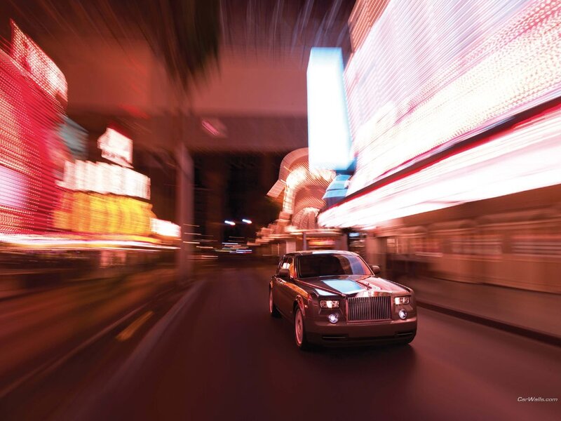 Rolls-Royce on a neon-lit street