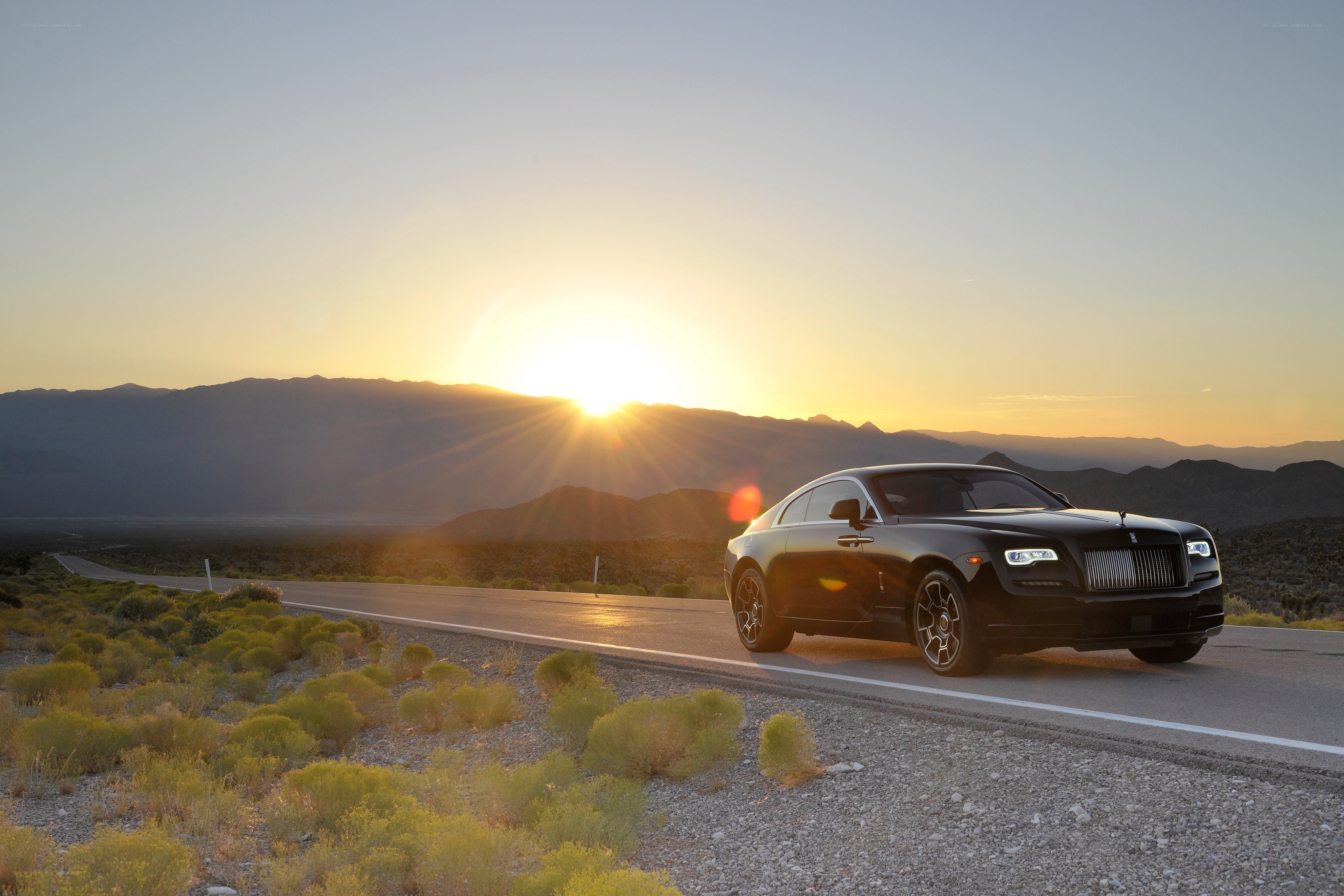 Rolls-Royce on desert road at sunset