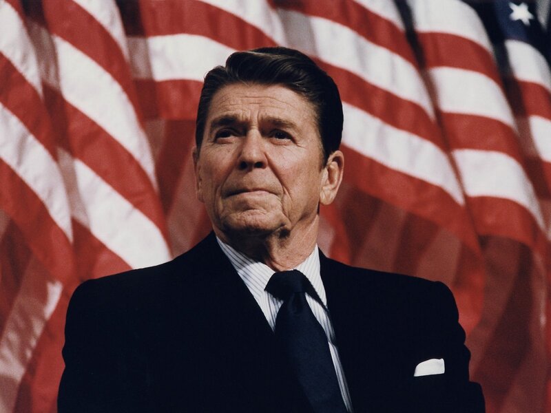 Ronald Reagan in front of American flags