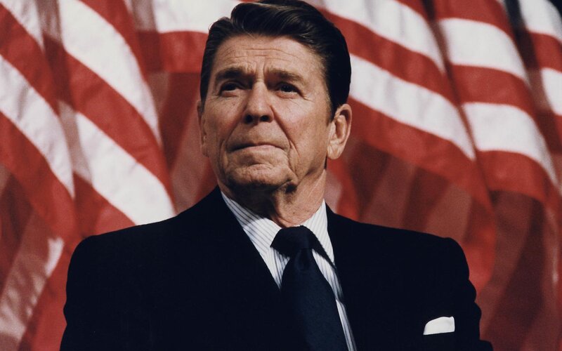 Ronald Reagan in front of American flags