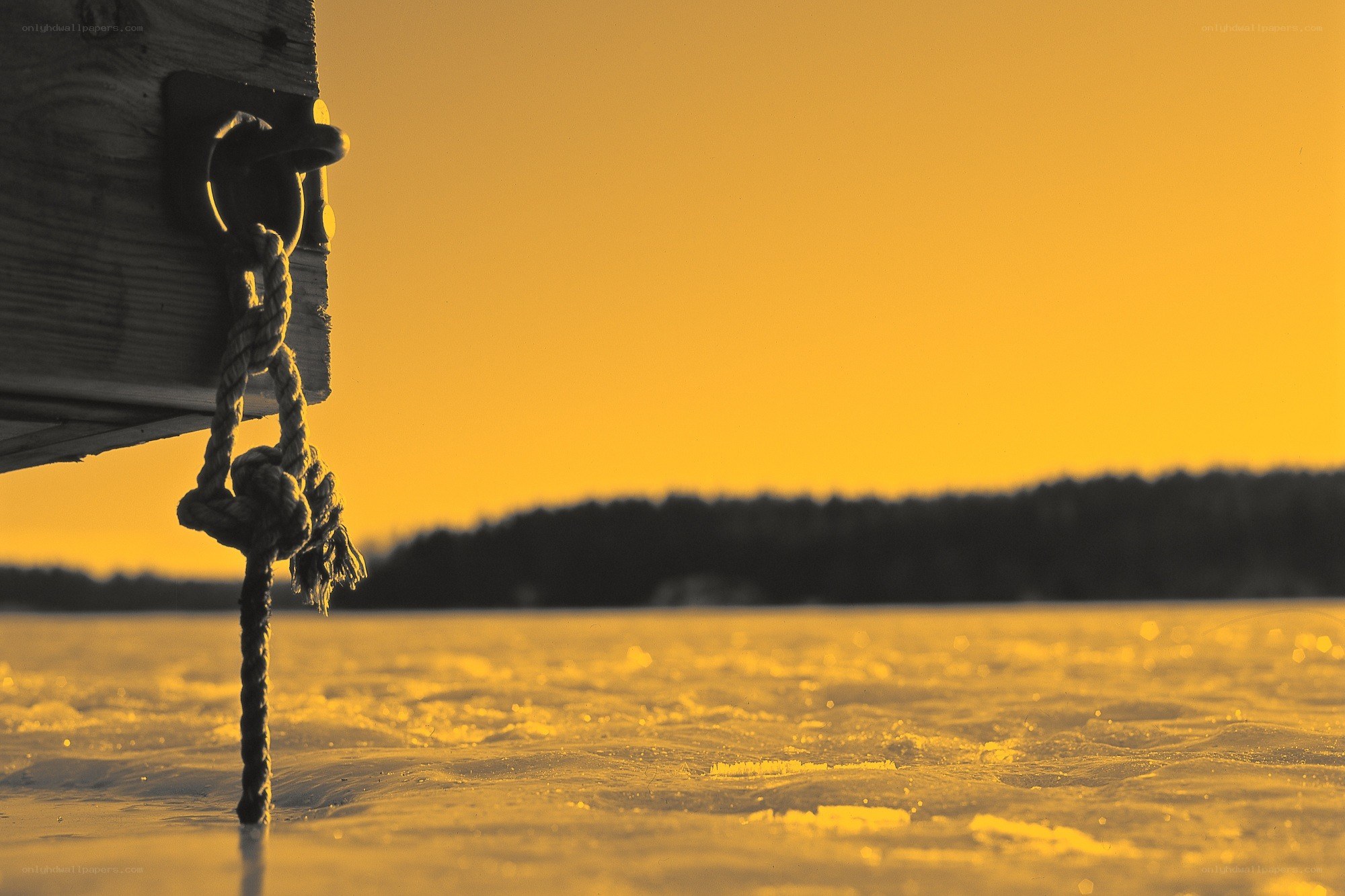 Rope on frozen lake at sunset