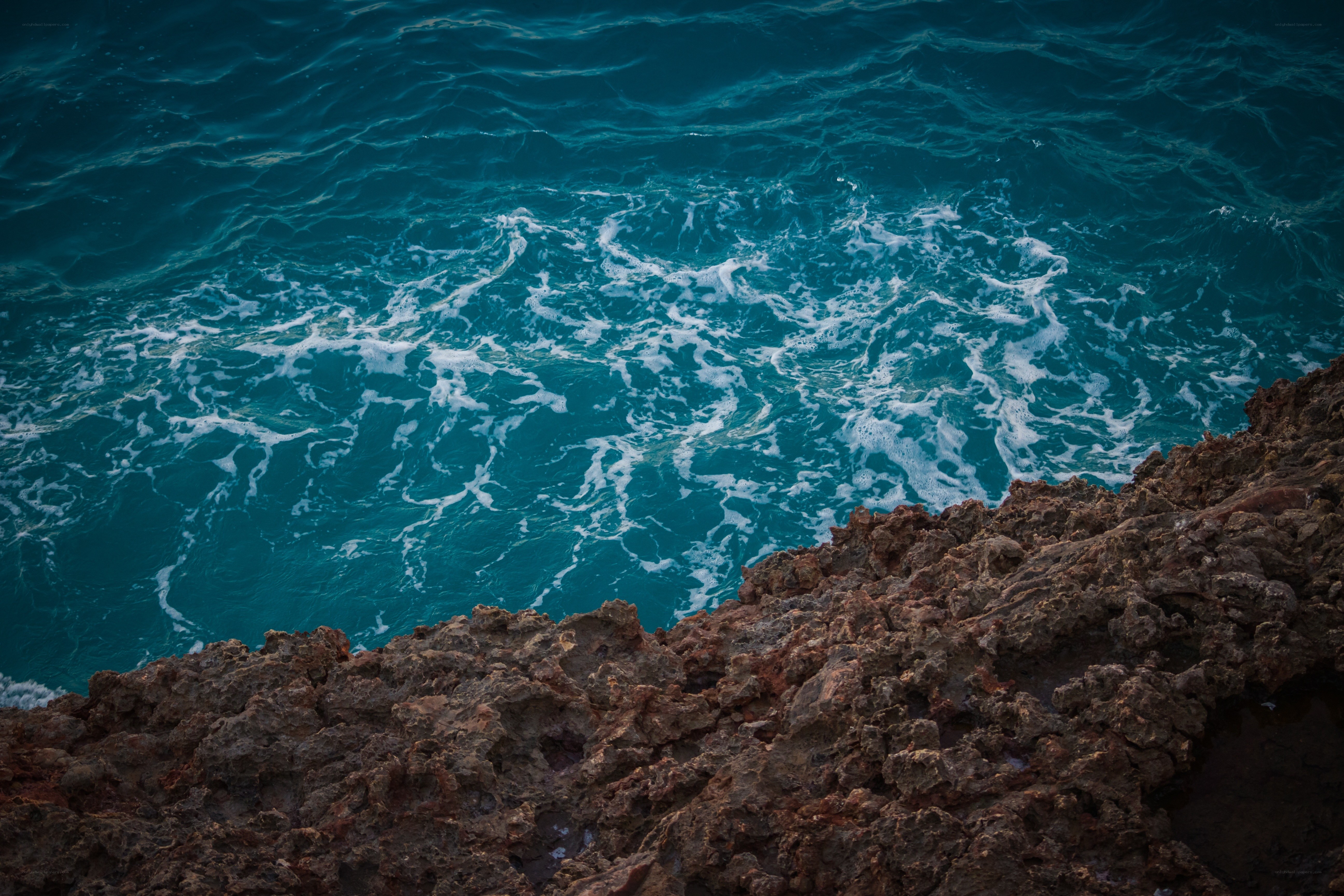 Rough rocks meet turquoise waves
