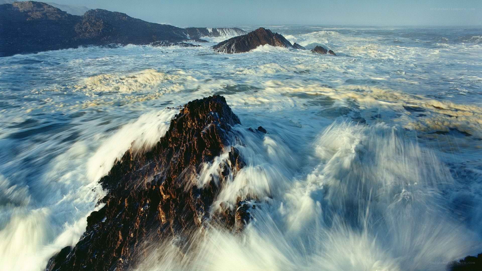 Rough waves crash on rocky shore