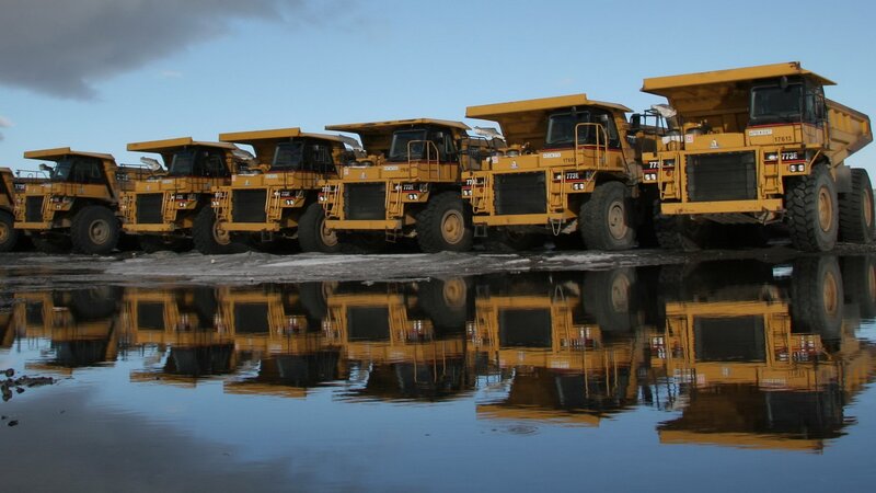 Row of dump trucks in reflection