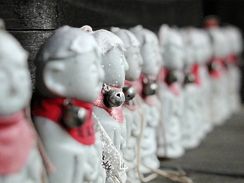 Row of white figurines with bells