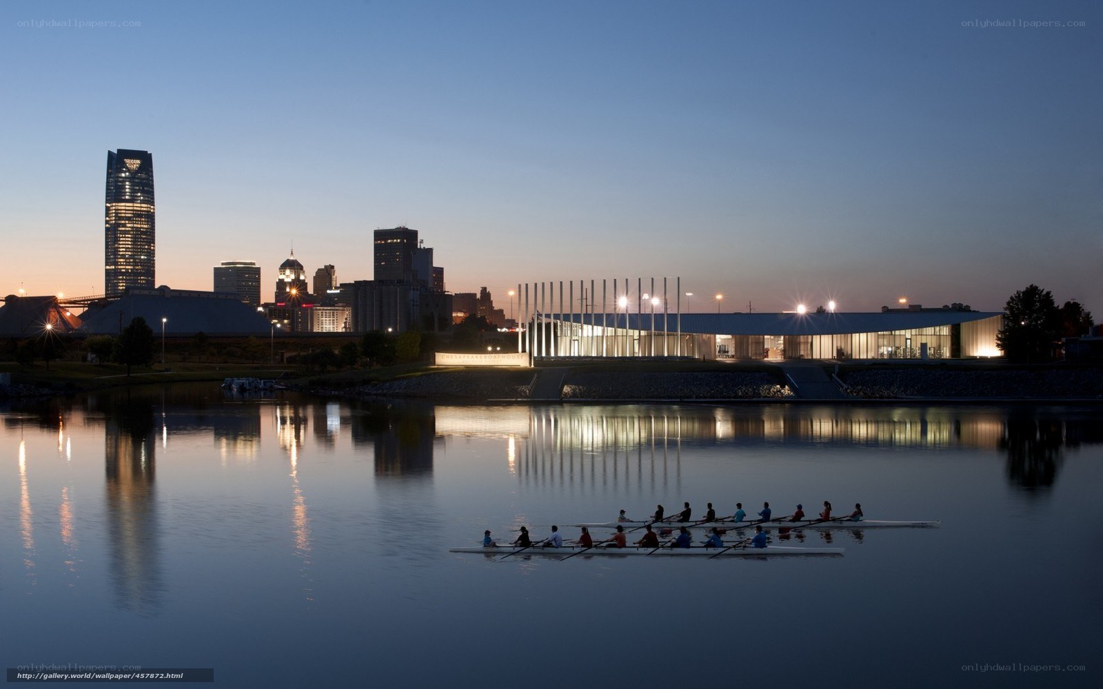 Rowers on a city river at dusk