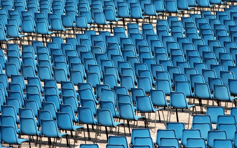 Rows of blue chairs in an auditorium