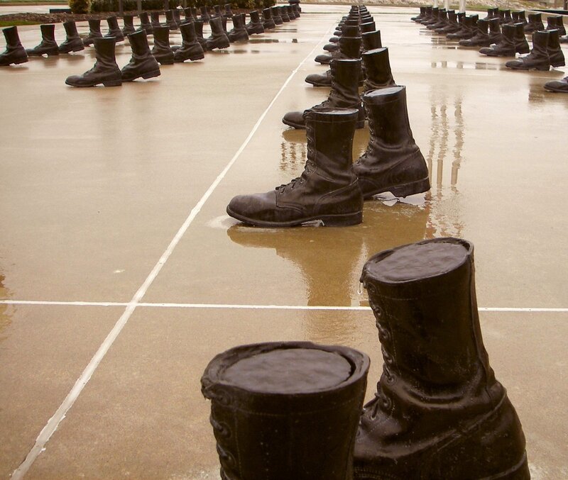 Rows of boots on wet pavement