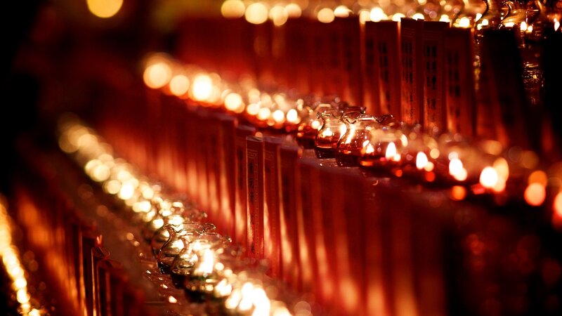 Rows of lit candles in a temple