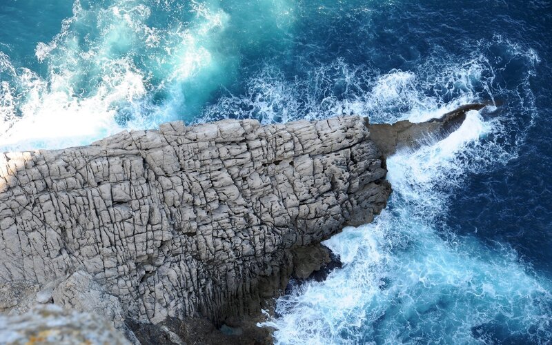 Rugged cliff overlooking crashing waves