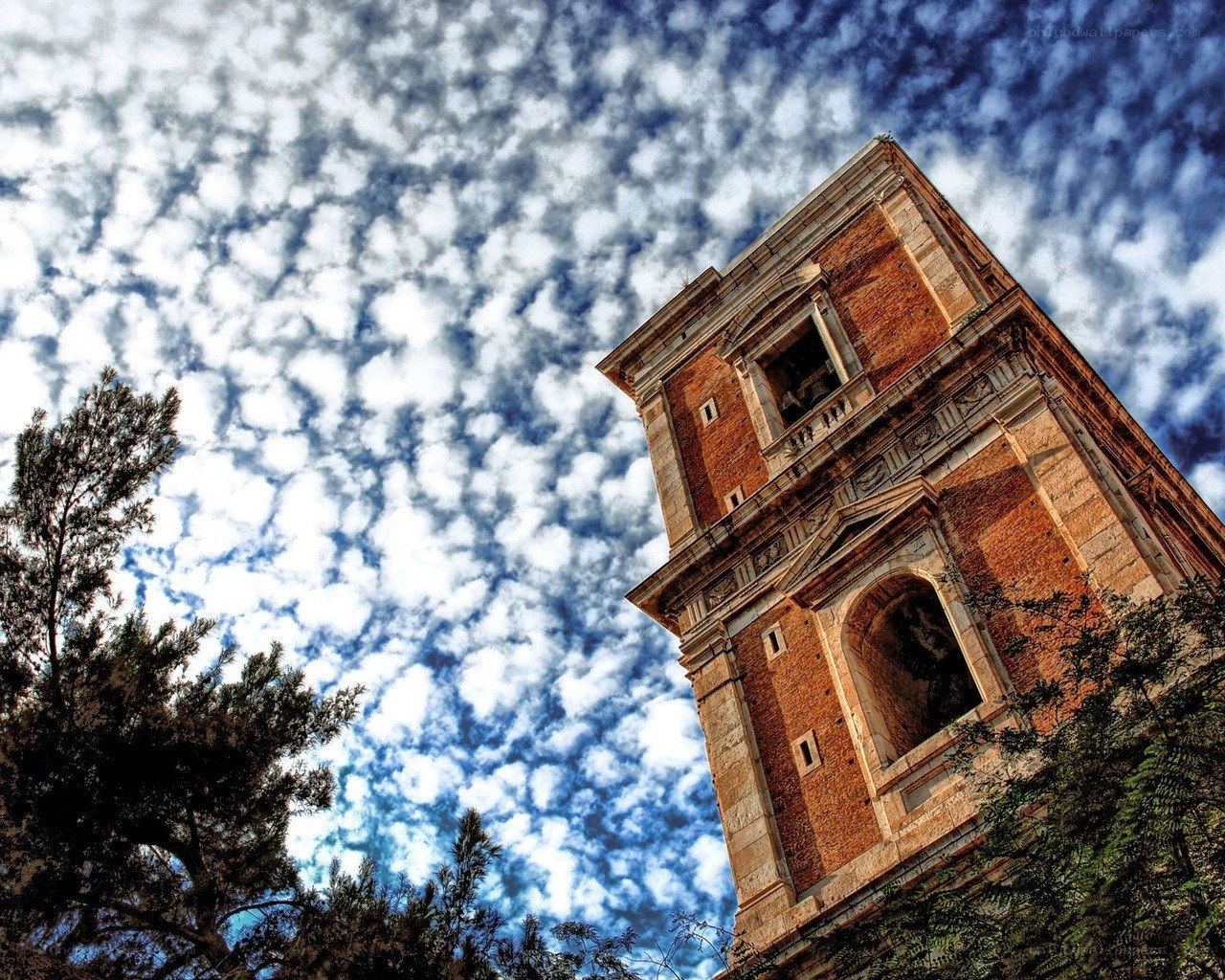 Ruined bell tower under cloudy sky