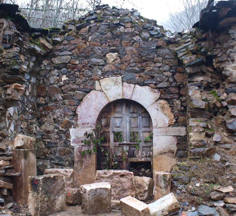 ruined stone building with arched door