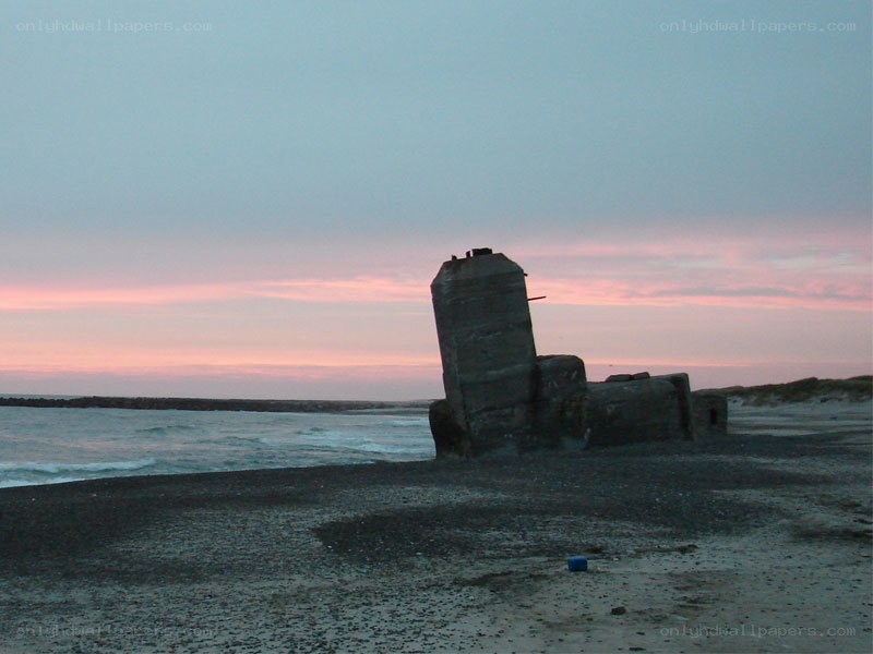 ruined structure on beach at dusk