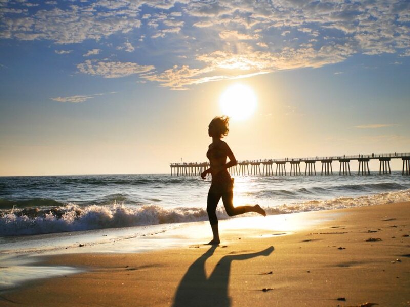 Runner on beach at sunset