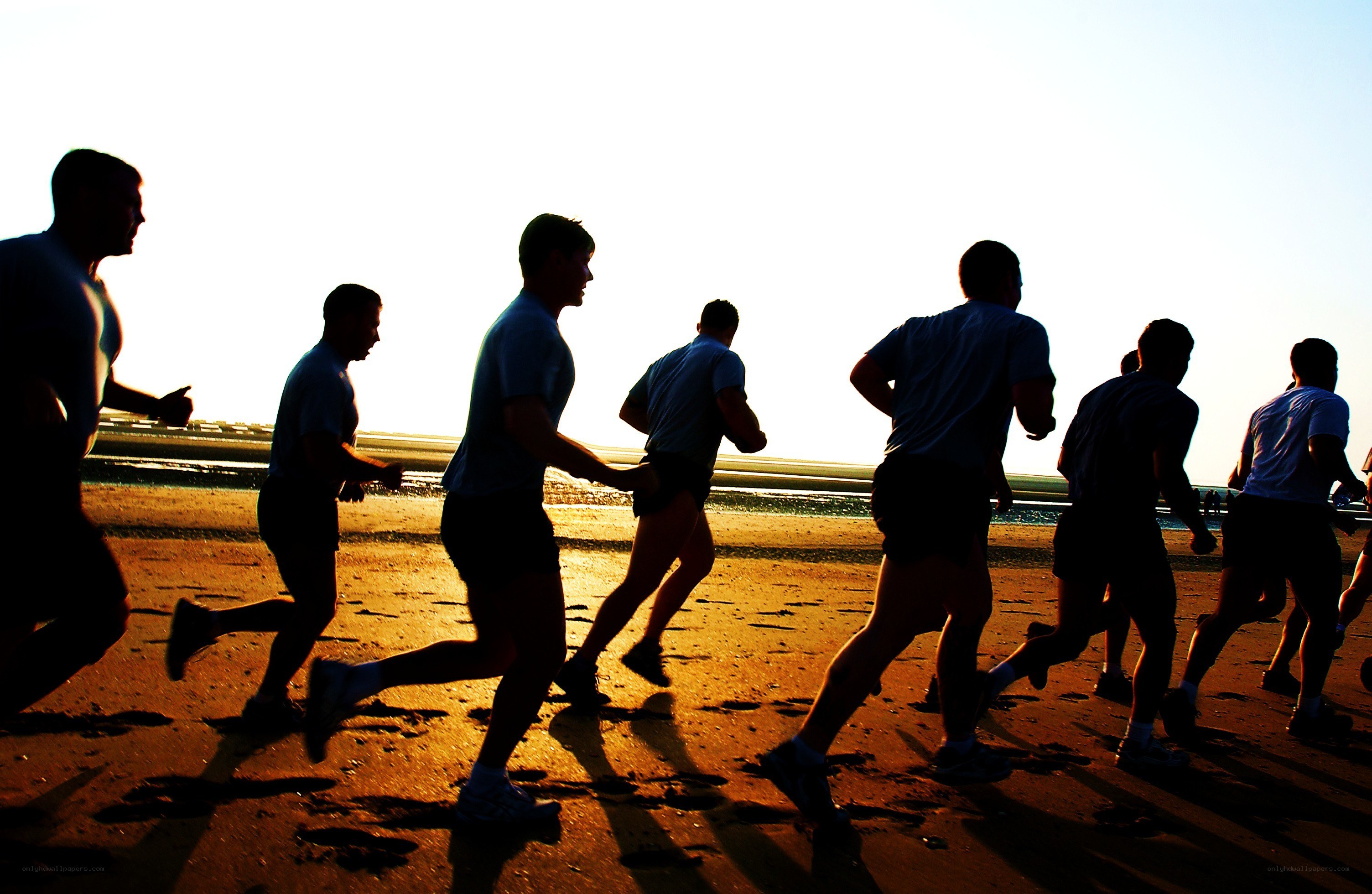 runners on the beach at sunset
