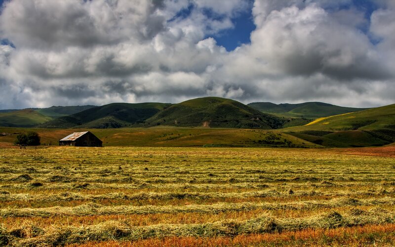 Rural field with barn and hills