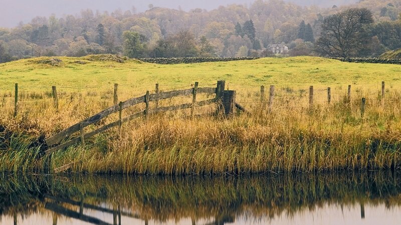 Rural landscape with lake and fence