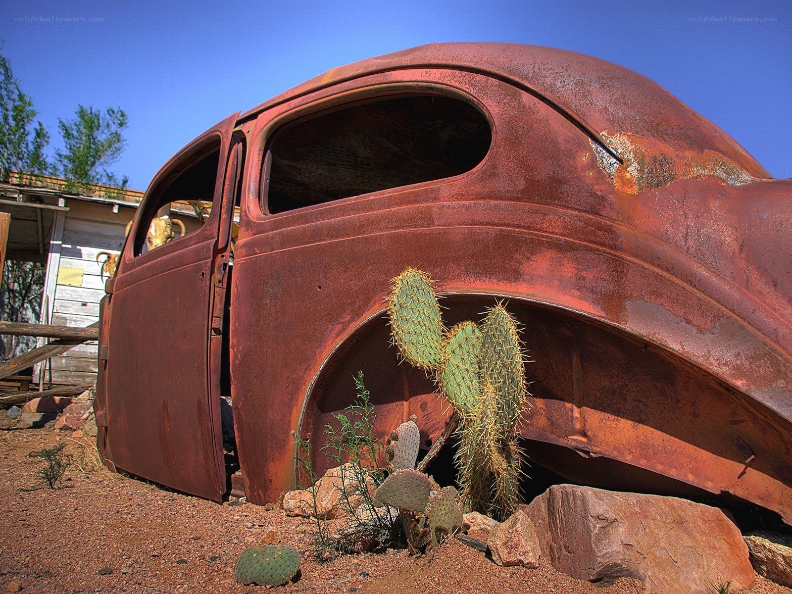 Rusted car in desert landscape
