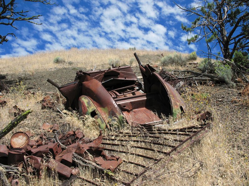 Rusted car wreck on hillside