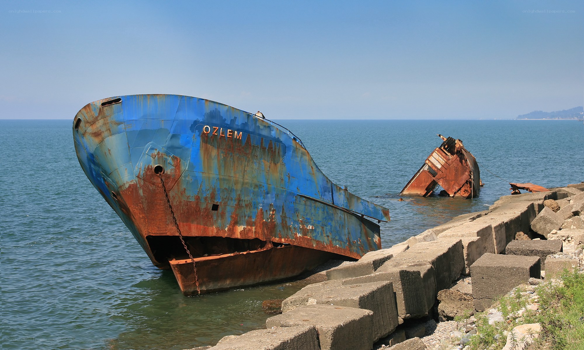 Rusted shipwreck on a breakwater
