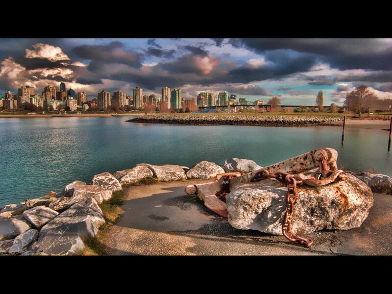 Rusty anchor by city skyline