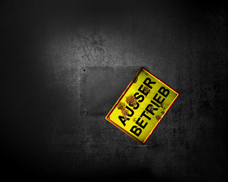 Rusty 'Außer Betrieb' sign on wall