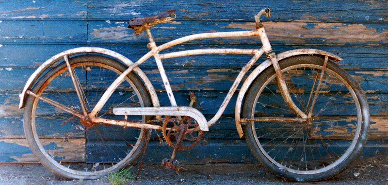 Rusty Bicycle Against Wall