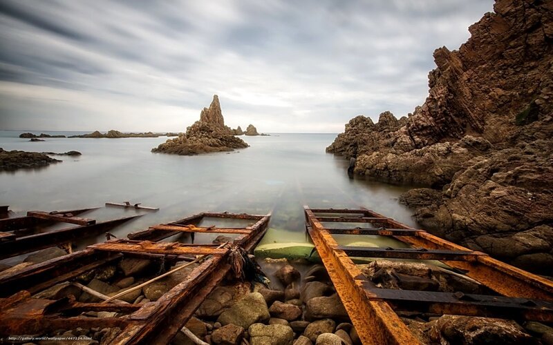 Rusty boat frames on rocky shore