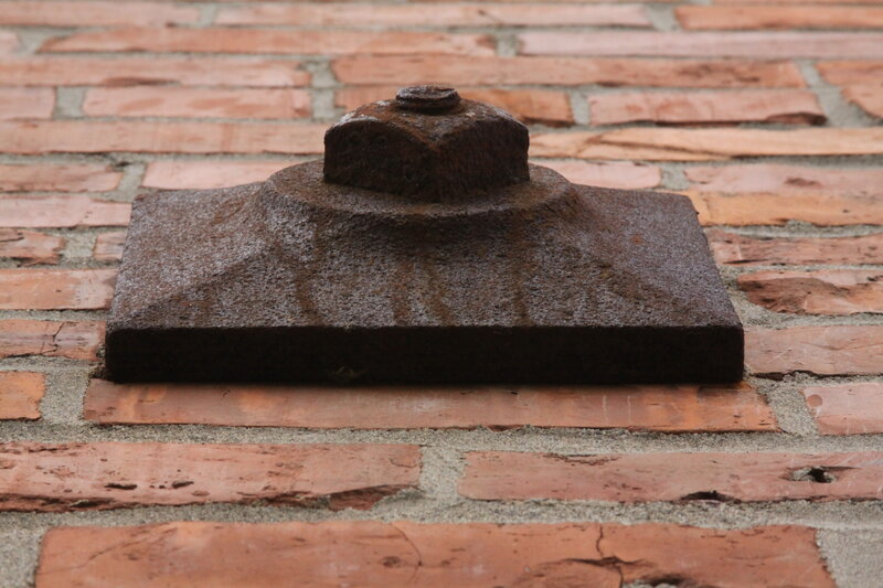 Rusty bolt on brick wall
