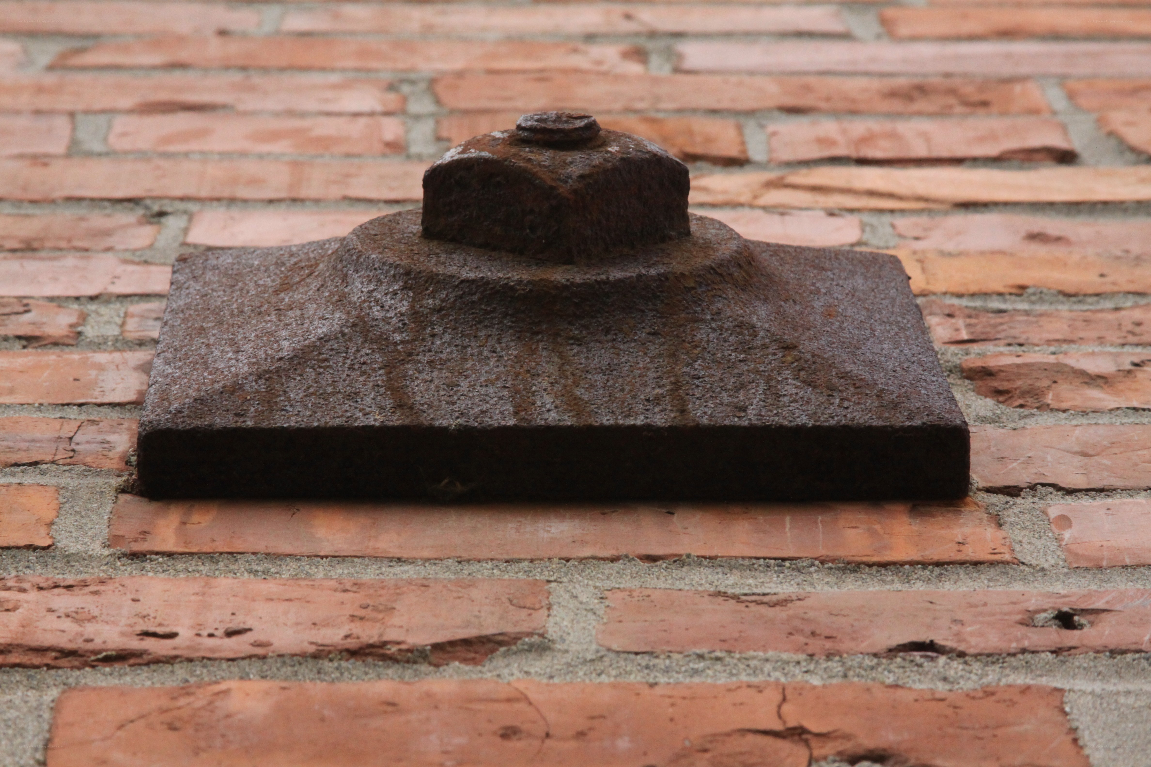Rusty bolt on brick wall