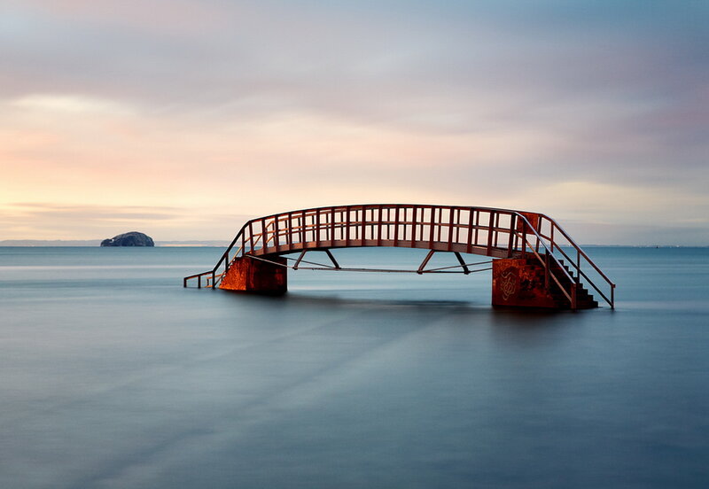 Rusty bridge over calm sea