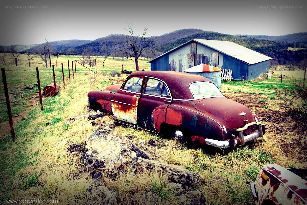Rusty car in a rural field